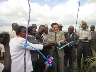 Cutting ribbon in front of school water tank