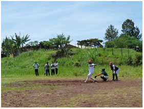 Youth playing baseball on cricket ground